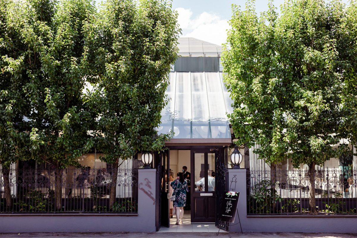 The entrance to St Andrews Conservatory on King William Street: a dark double door between two pear trees, with a chalkboard welcome sign