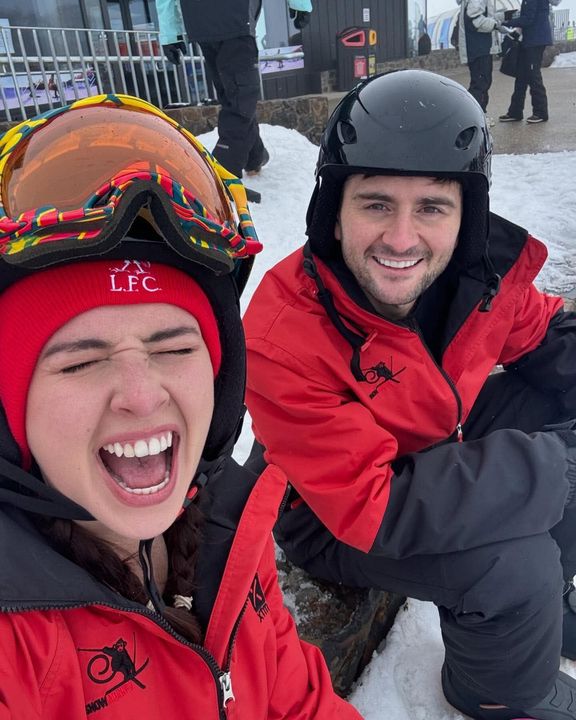 Phoebe and Hayden in red snow jackets on the mountain