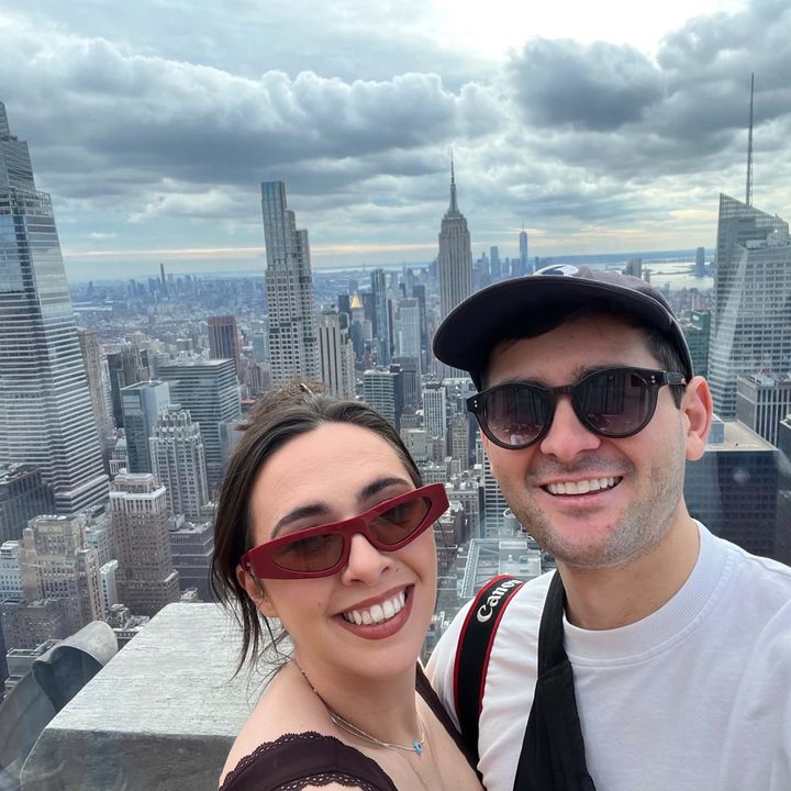 Hayden and Phoebe in sunglasses on a rooftop above the New York skyline