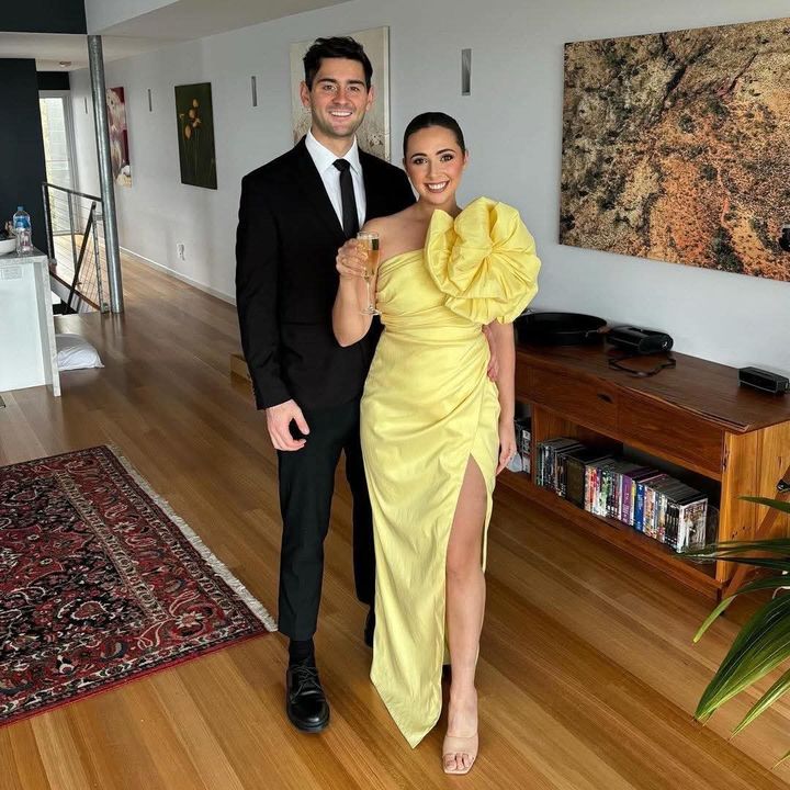 Hayden and Phoebe dressed up, raising a glass of champagne
